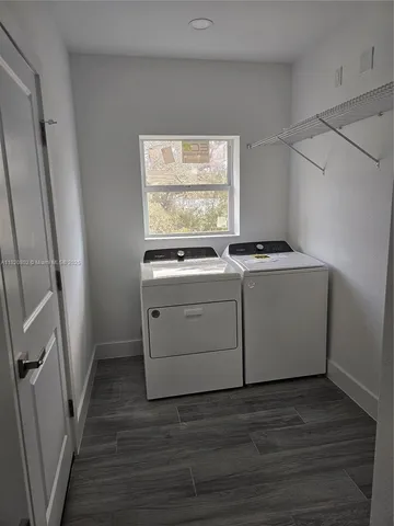 a utility room with wooden floor washer and dryer