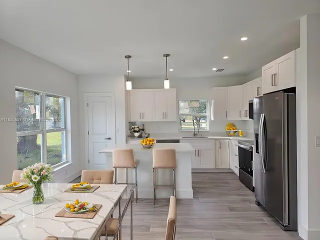 a kitchen with a refrigerator and a dining table