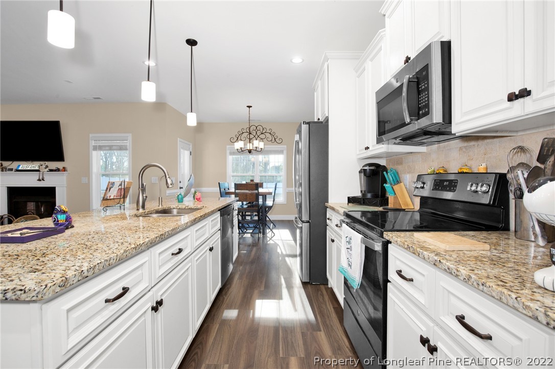 2624 Riddle Farm Road Hope Mills, NC 28348 - Photo 12 of 33 a kitchen with stainless steel appliances granite countertop a stove and a sink