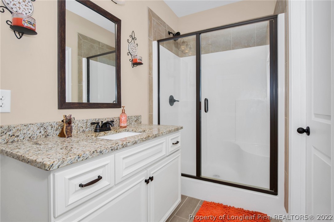 2624 Riddle Farm Road Hope Mills, NC 28348 - Photo 22 of 33 a bathroom with a granite countertop sink and a mirror