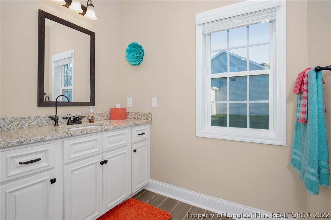 2624 Riddle Farm Road Hope Mills, NC 28348 - Photo 23 of 33 a bathroom with a granite countertop sink and a mirror