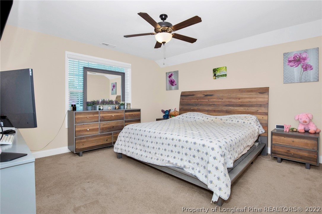 2624 Riddle Farm Road Hope Mills, NC 28348 - Photo 24 of 33 a bedroom with a bed and a chandelier