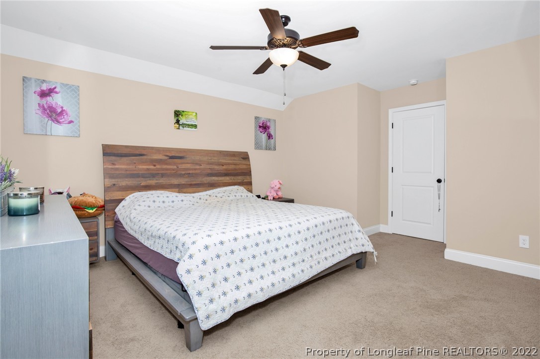 2624 Riddle Farm Road Hope Mills, NC 28348 - Photo 25 of 33 a bedroom with a bed and a chandelier