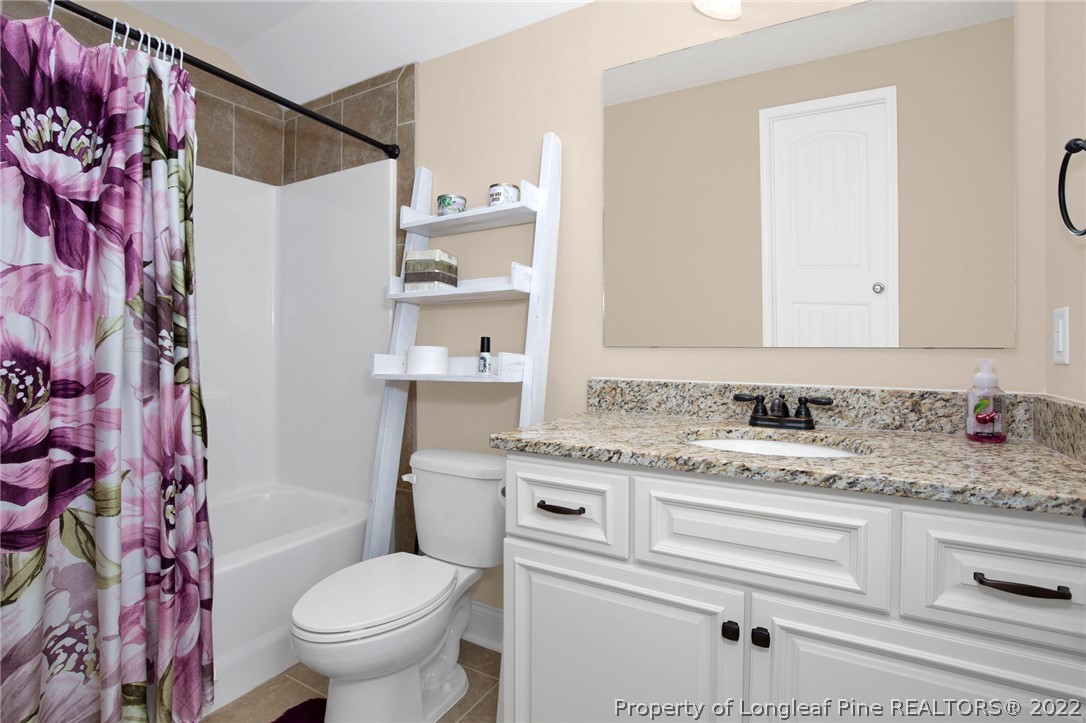 2624 Riddle Farm Road Hope Mills, NC 28348 - Photo 26 of 33 a bathroom with a granite countertop sink toilet and shower