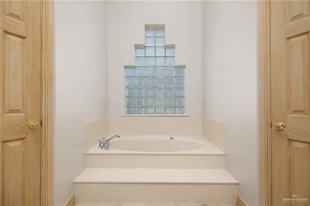 a bathroom with bathtub and window