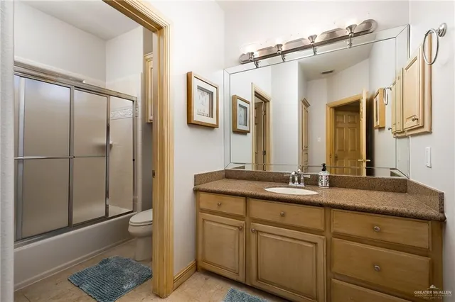 a bathroom with a granite countertop sink a mirror and a shower