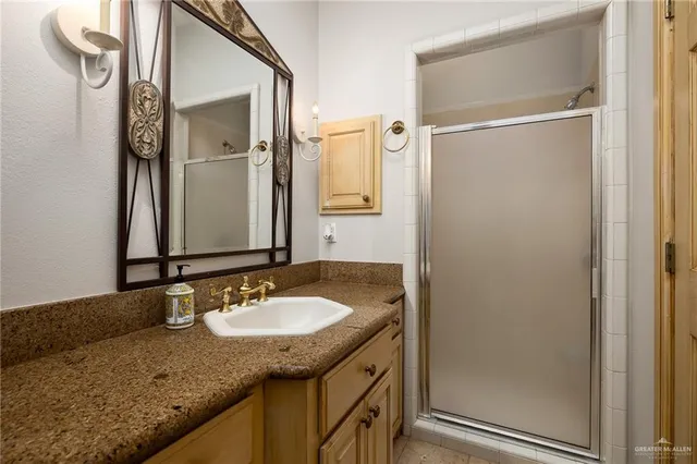 a bathroom with a granite countertop sink and a mirror