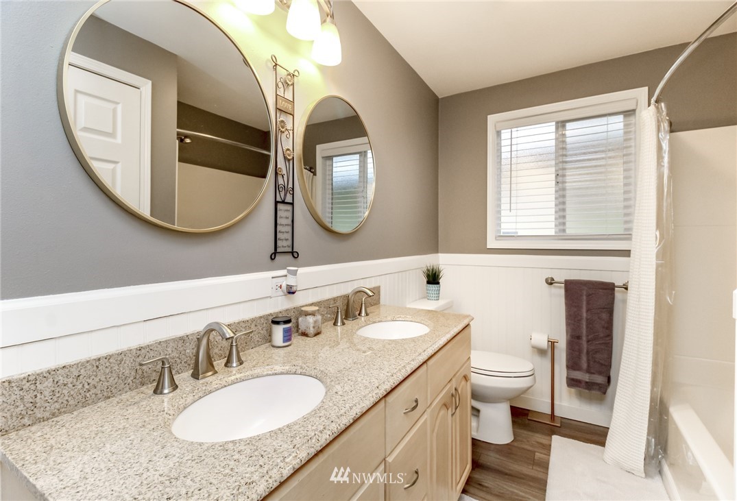 17021 Southeast Jones Road Renton, WA 98058 - Photo 14 of 27 a bathroom with a granite countertop toilet a sink and a mirror