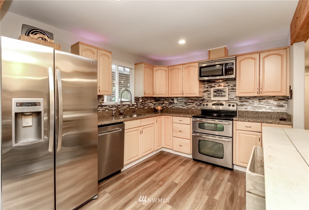 17021 Southeast Jones Road Renton, WA 98058 - Photo 6 of 27 a kitchen with stainless steel appliances a refrigerator sink and microwave