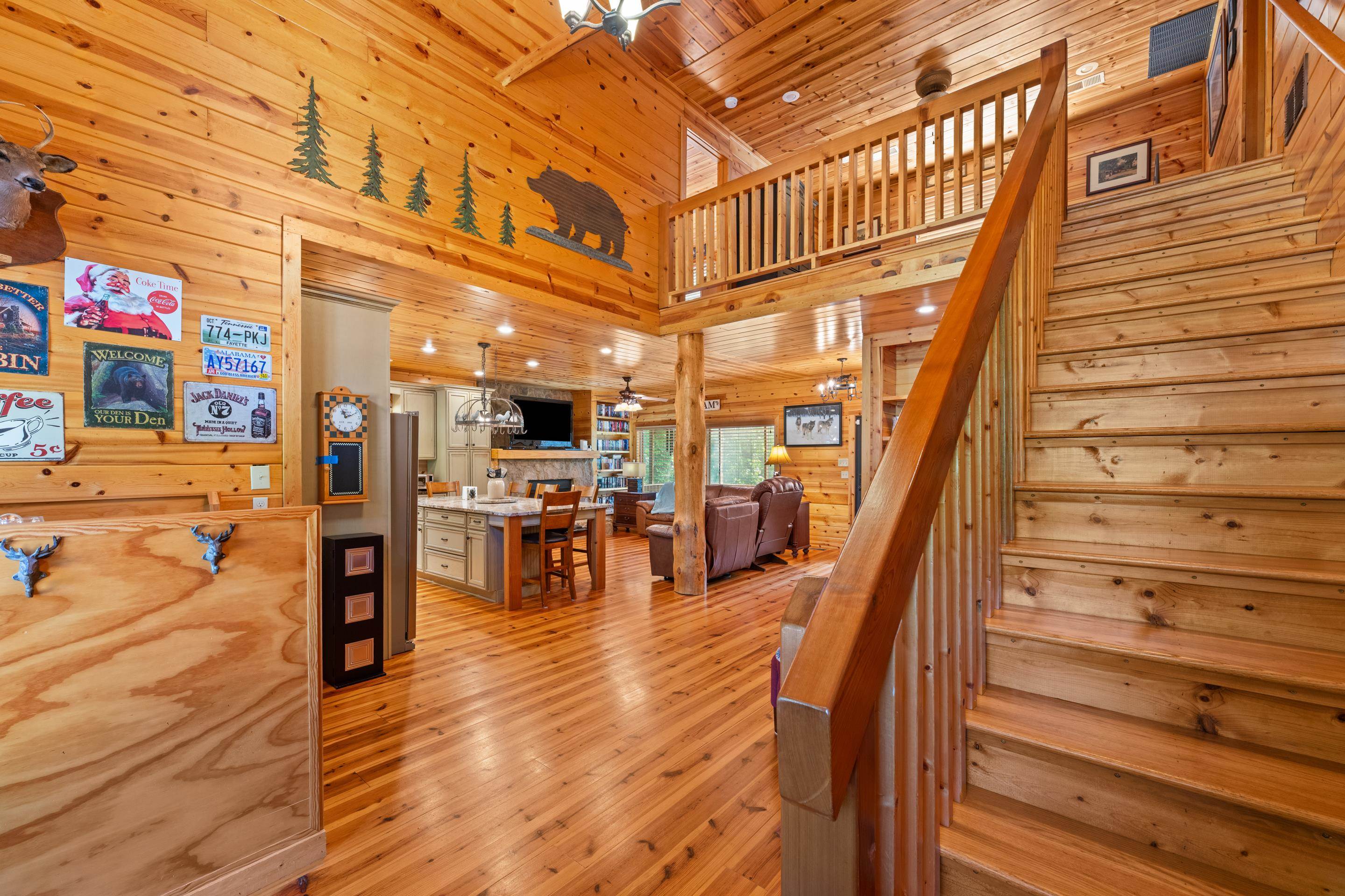 950 Cherry Road Eads, TN 38028 - Photo 9 of 30 Two-story interior showcasing extensive wood-finish walls and ceilings, a wooden staircase, and a second-story balcony