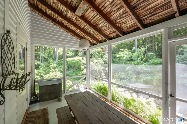 a view of a porch with furniture and wooden floor