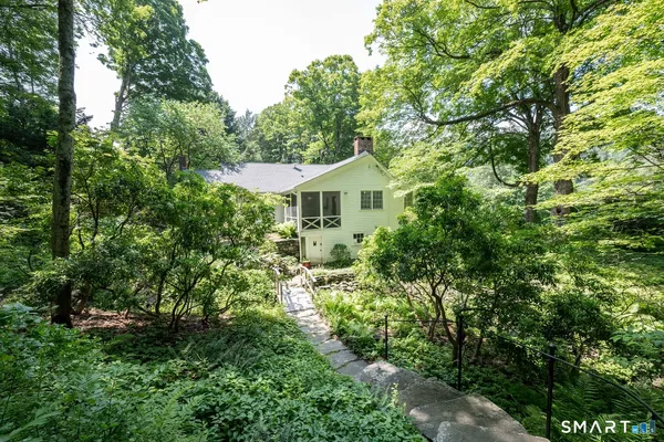 a view of a house with a yard and potted plants