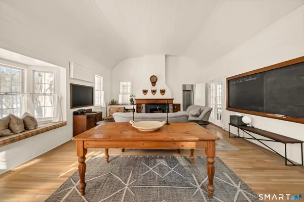 a living room with furniture a flat screen tv and a large window