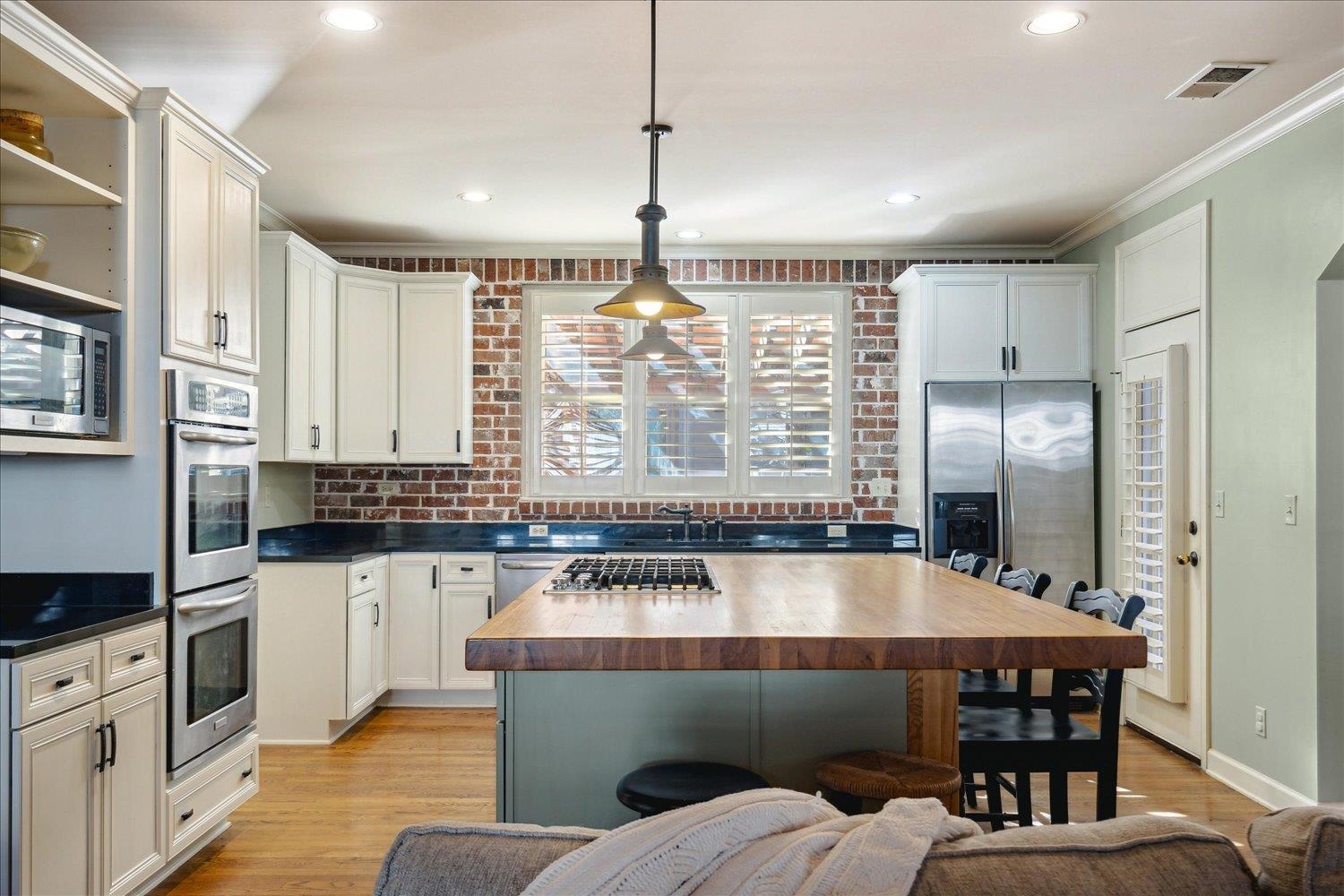 307 Colbert Street West Collierville, TN 38017 - Photo 10 of 34 Kitchen featuring ornamental molding, white cabinets, pendant lighting, light wood-type flooring, and stainless steel appliances