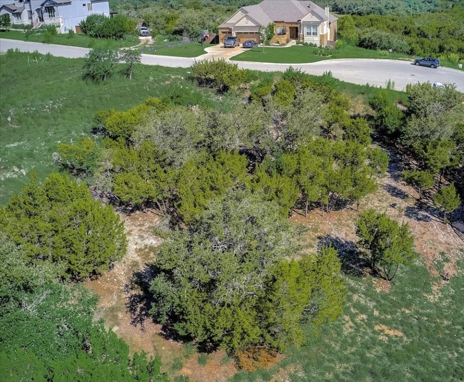 an aerial view of residential house with outdoor space and trees all around