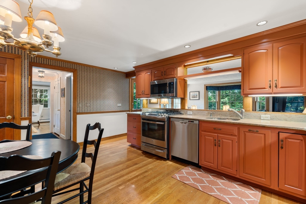 96 Elmwood Road Wellesley, MA 02481 - Photo 11 of 40 a kitchen with stainless steel appliances granite countertop a stove top oven a sink dishwasher a dining table and chairs with wooden floor