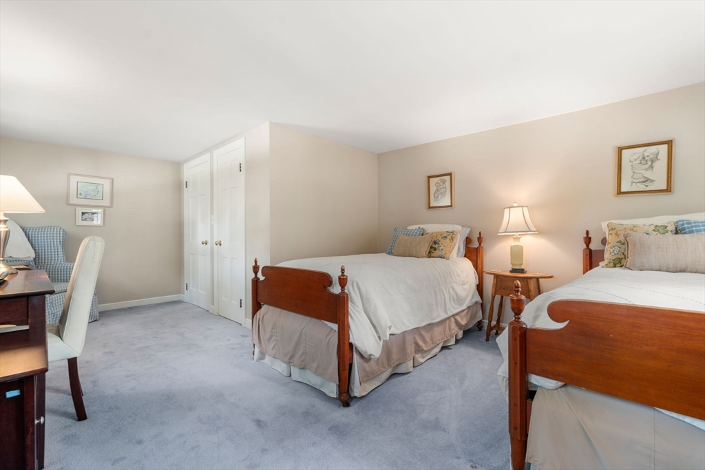 96 Elmwood Road Wellesley, MA 02481 - Photo 24 of 40 a spacious bedroom with a bed and a table in it