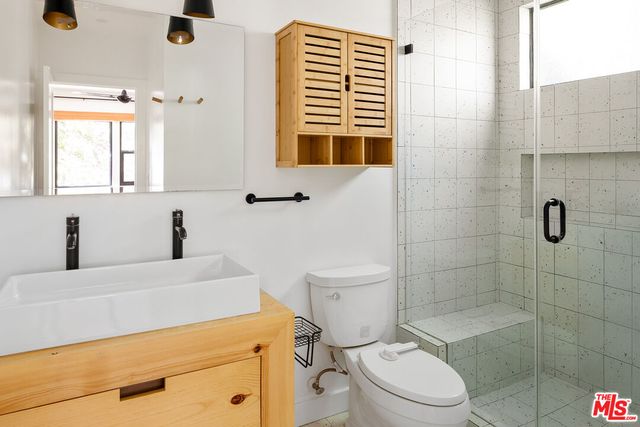 a bathroom with a sink a toilet and shower