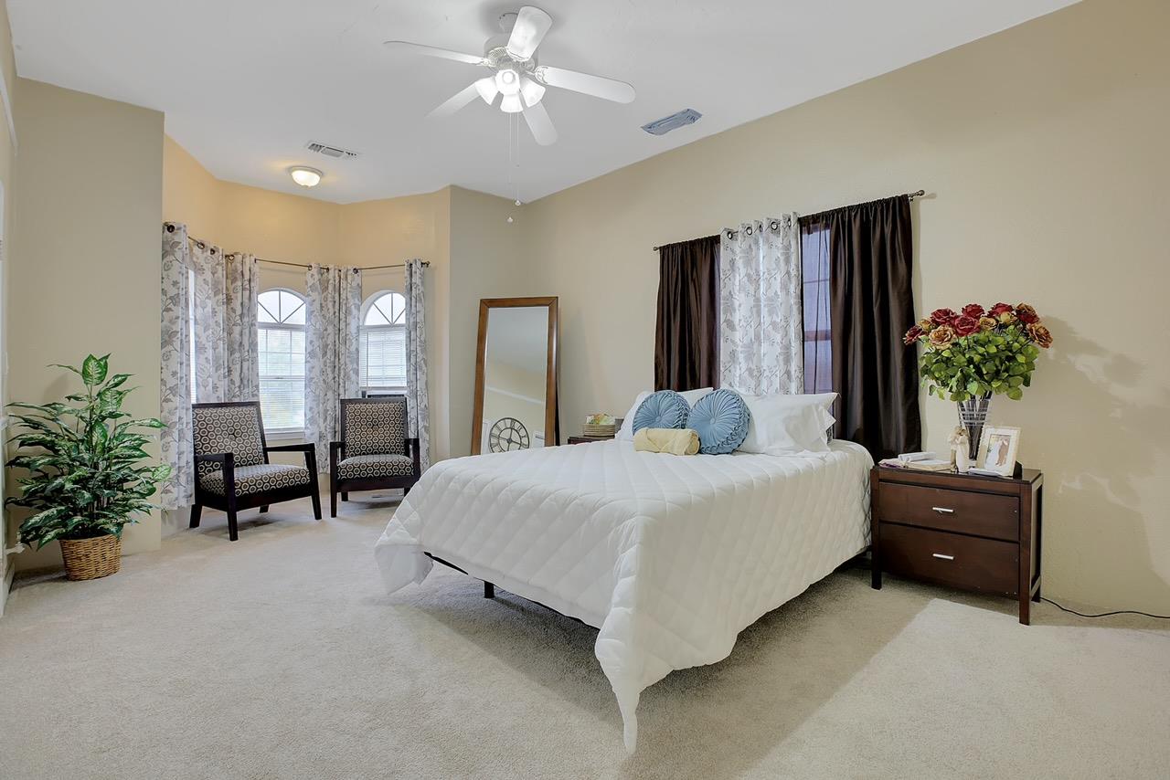 1408 Hazel Street Gridley, CA 95948 - Photo 32 of 60 a spacious bedroom with a large bed and a chandelier