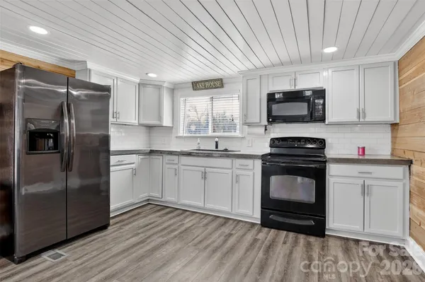 a kitchen with granite countertop a refrigerator stove and microwave