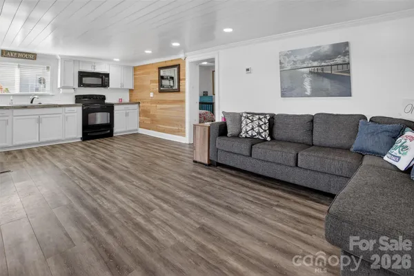 a kitchen with stainless steel appliances wooden floor and a refrigerator