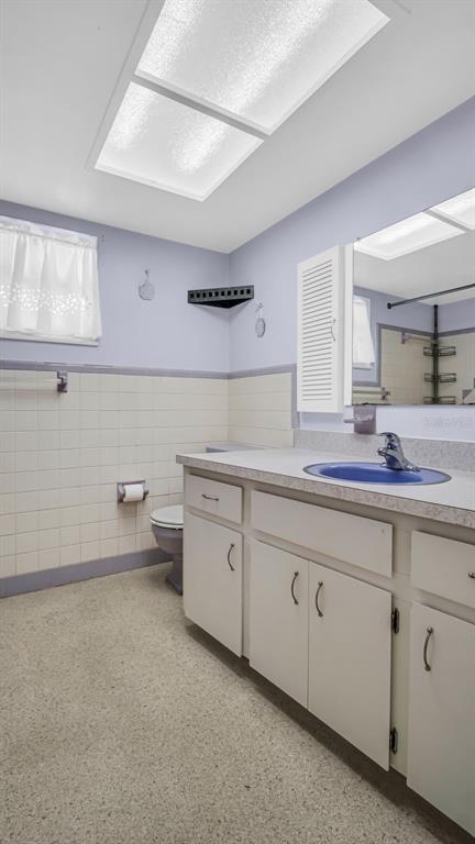 5831 Hillside Street Seminole, FL 33772 - Photo 23 of 26 a spacious bathroom with a granite countertop sink mirror and toilet