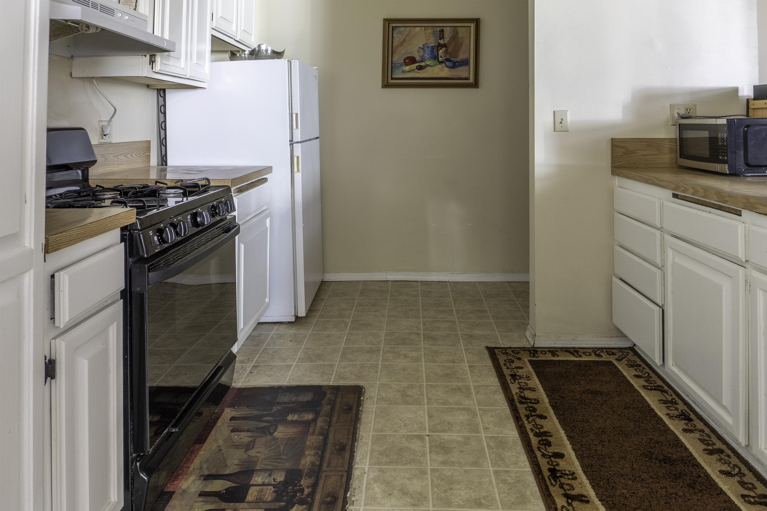 76 Alderman Street June Lake, CA 93529 - Photo 11 of 38 Kitchen featuring black range with gas stovetop, under cabinet range hood, stainless steel microwave