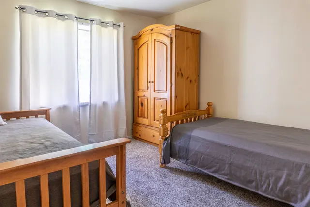 a bedroom with a bed a window and shower