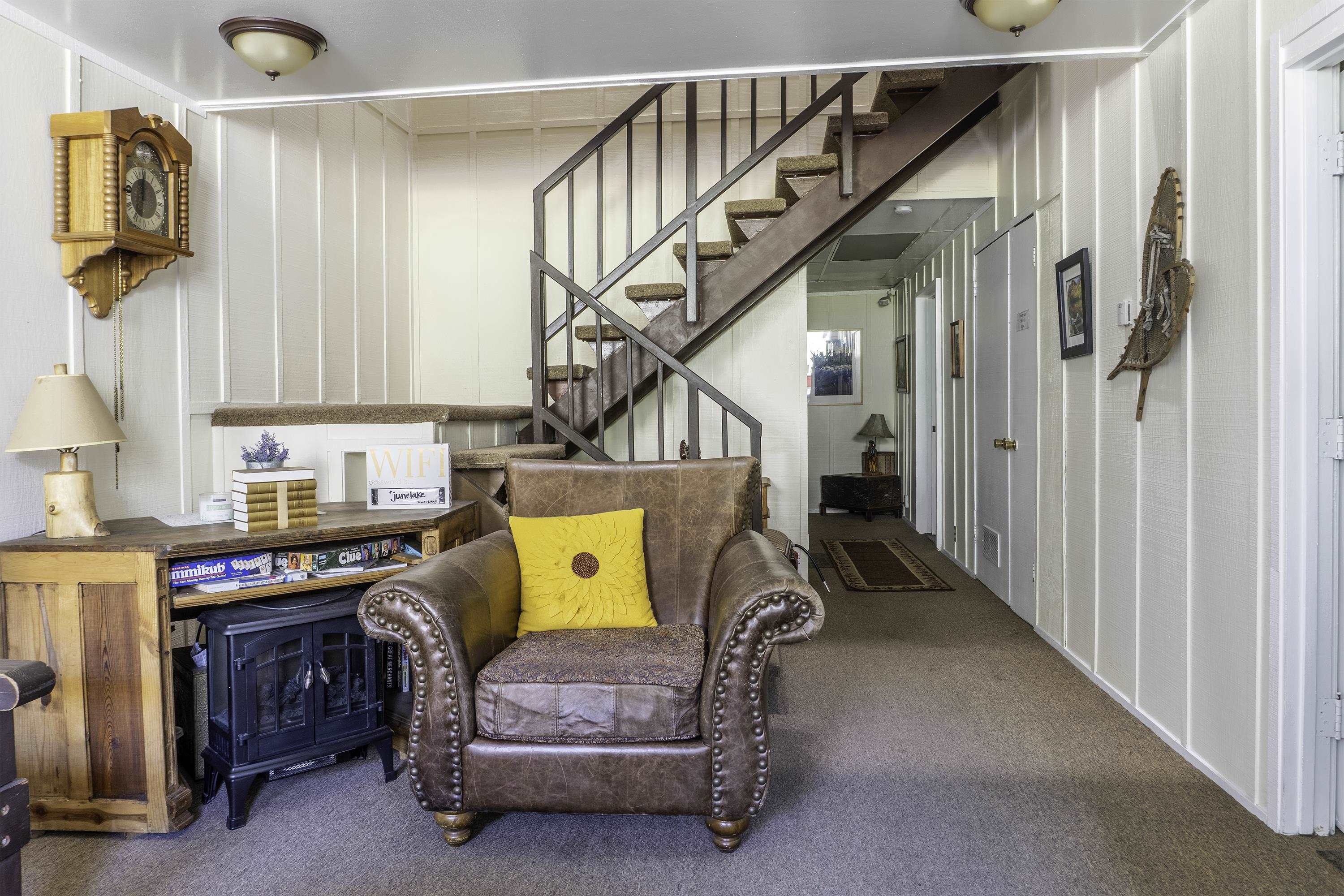76 Alderman Street June Lake, CA 93529 - Photo 14 of 38 Living area featuring carpet floors, stairs, and a decorative wall