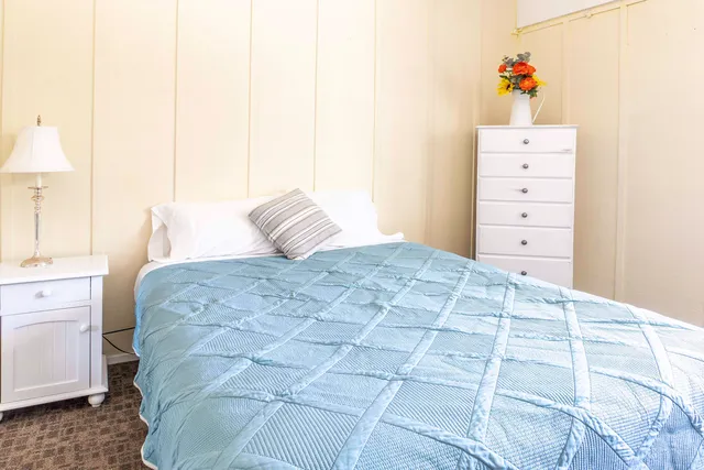 a bedroom with a large bed and a dresser