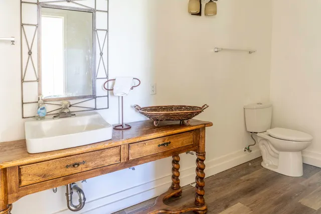 a bathroom with a toilet a sink and mirror