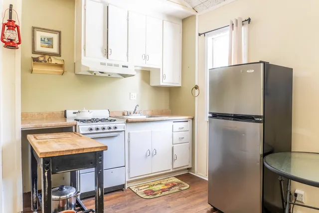a kitchen with stainless steel appliances granite countertop a refrigerator sink and stove