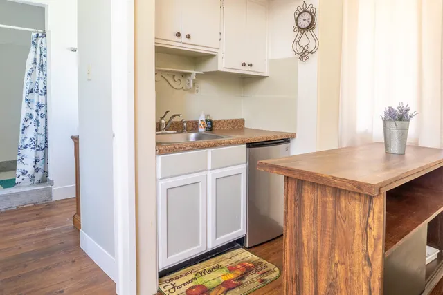 a kitchen with white cabinets and sink