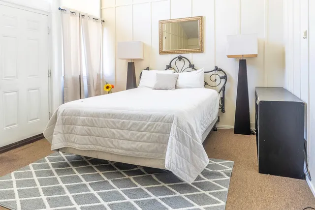 a bedroom with a bed and a mirror