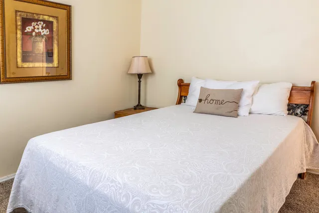 a large bed sitting in a bedroom next to a lamp