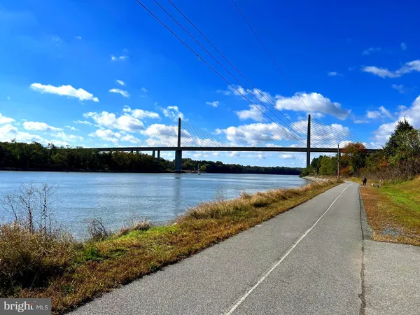 a view of a white house with a large tree