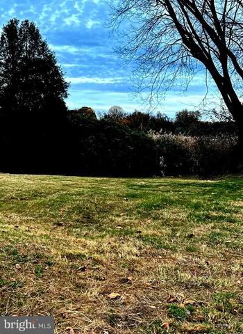 a view of a house with a bench in a yard