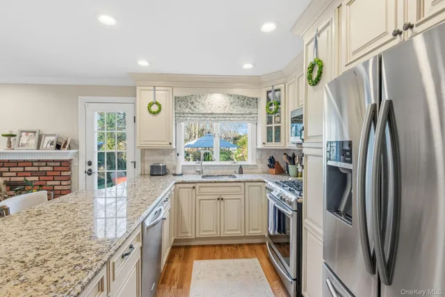 a living room with stainless steel appliances kitchen island granite countertop furniture a rug and a kitchen view