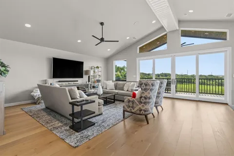 a open kitchen with stainless steel appliances granite countertop a stove a sink a oven a dining table and chairs with wooden floor