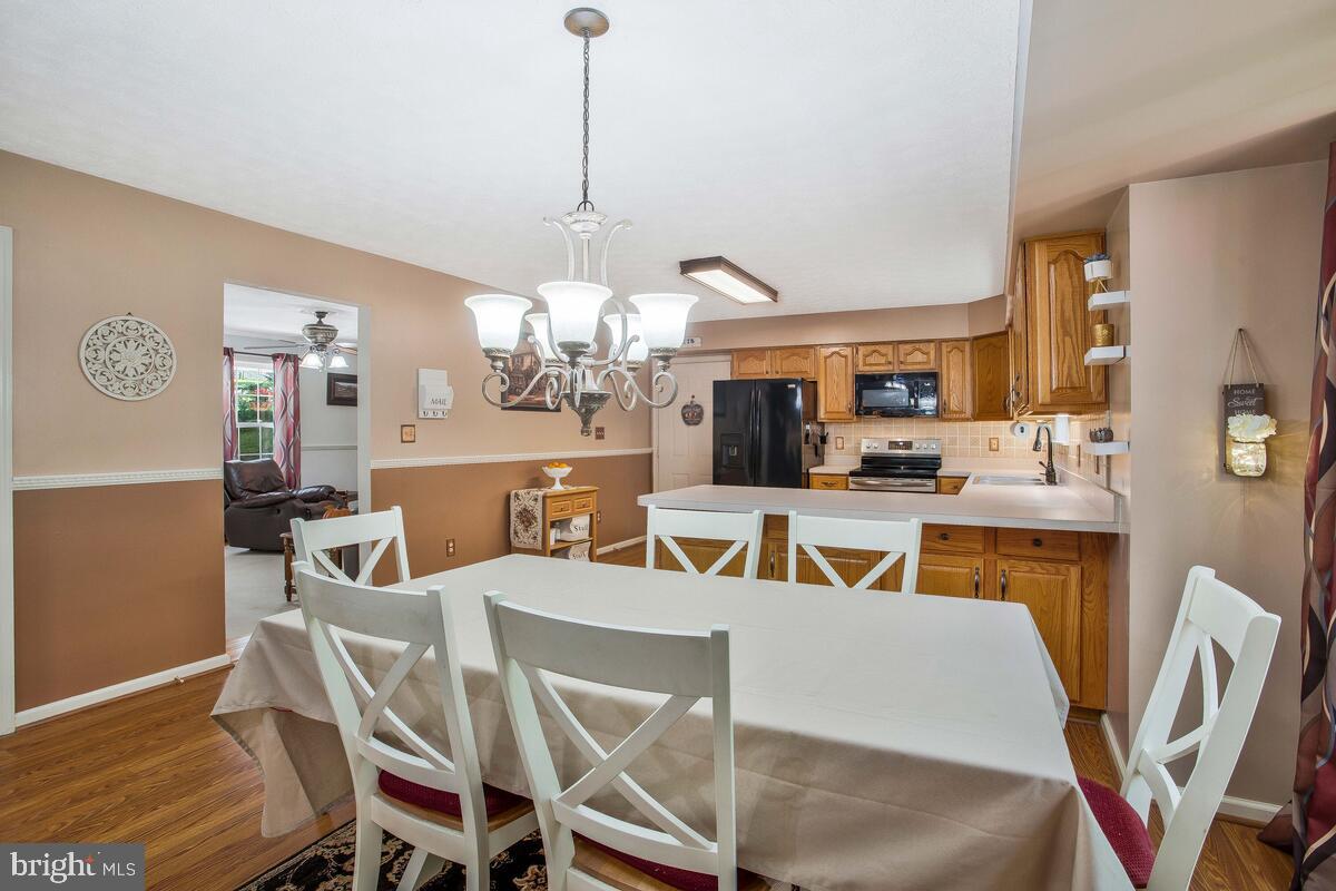 165 Ball Road St. Leonard, MD 20685 - Photo 20 of 55 a view of a dining room with furniture a chandelier and wooden floor
