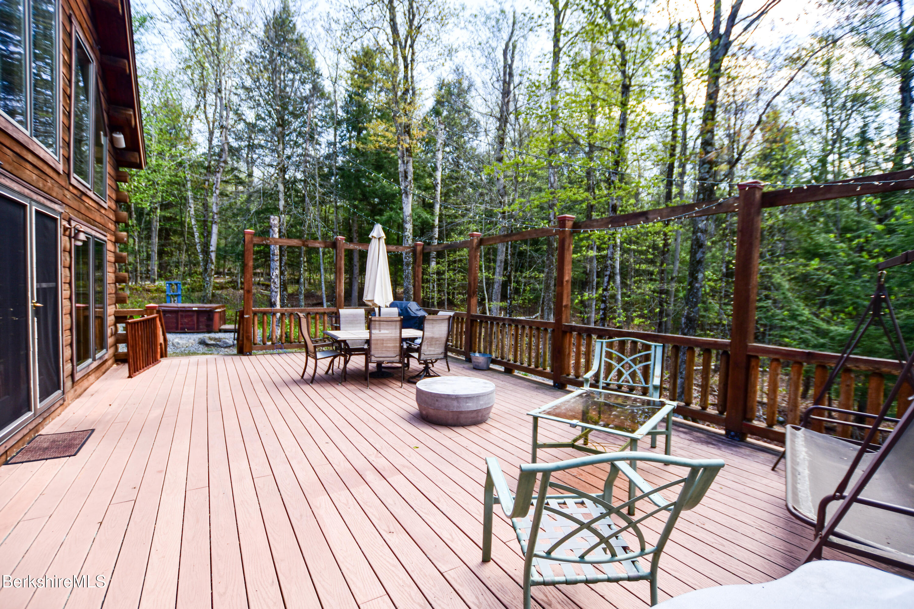 233 Algerie Road Becket, MA 01223 - Photo 45 of 48 a view of a patio with couches table and chairs and wooden floor