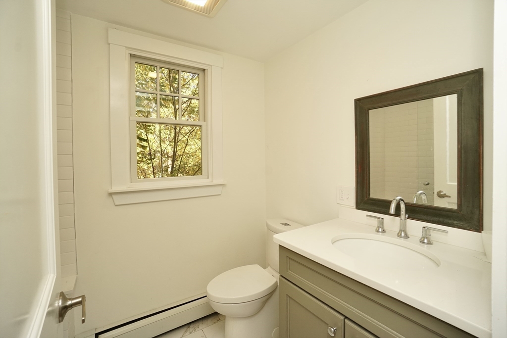 2 Thaxter Road Newton, MA 02460 - Photo 14 of 36 a bathroom with a granite countertop toilet a sink and a mirror
