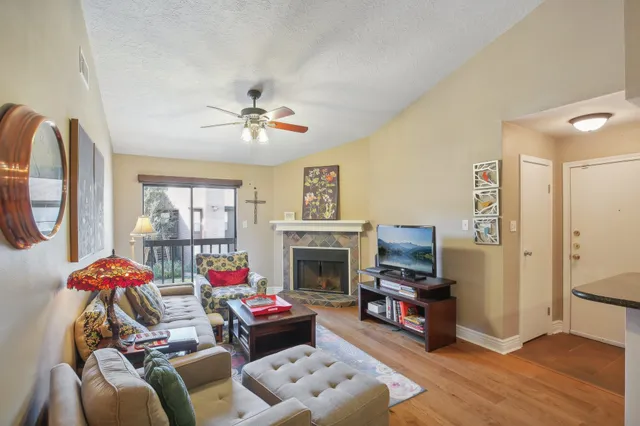 a living room with furniture a fireplace and a flat screen tv