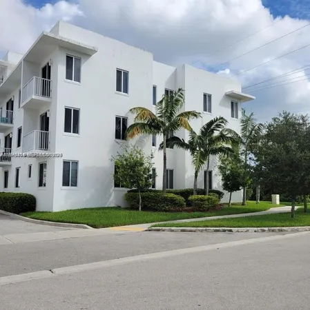 a front view of a house with a garden and trees