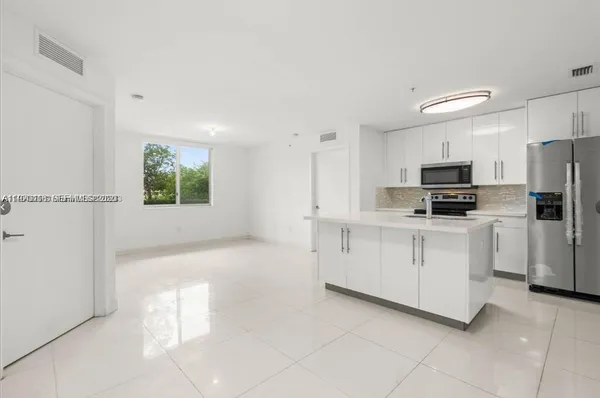 a kitchen with white cabinets and stainless steel appliances