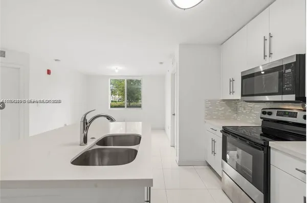a kitchen with granite countertop a sink and a stove top oven with granite countertops