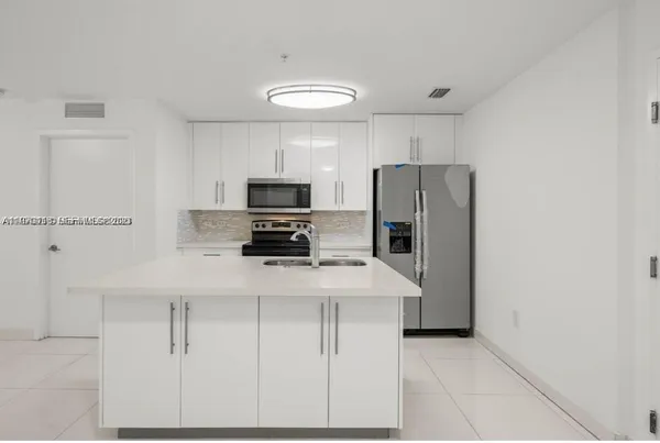 a kitchen with cabinets and stainless steel appliances