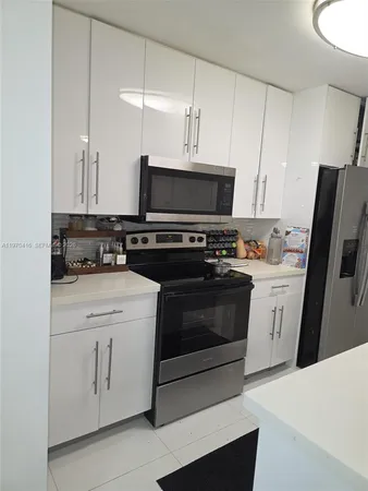 a kitchen with stainless steel appliances a stove a sink and a refrigerator