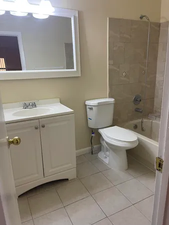 a bathroom with a toilet sink and mirror