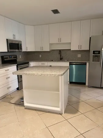 a kitchen with granite countertop a stove and a sink